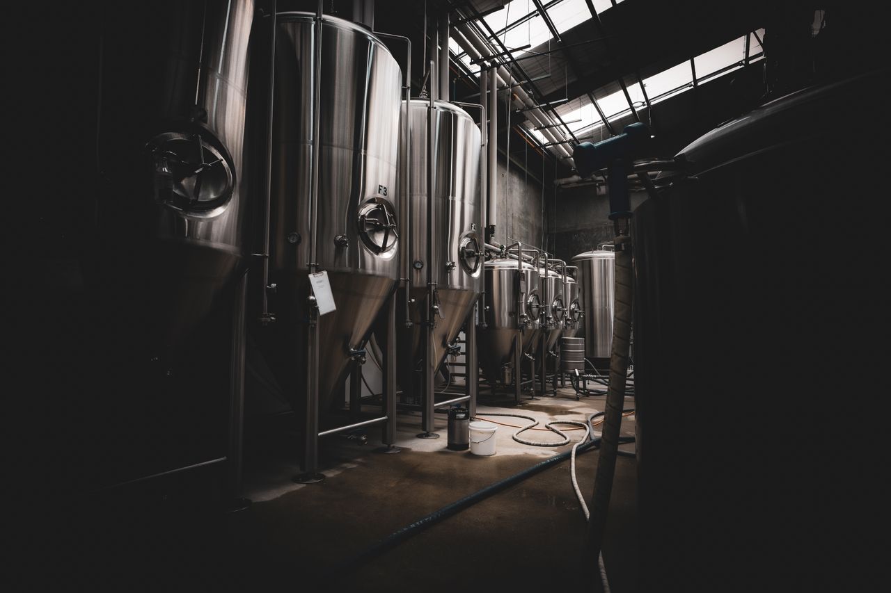 Mastering the First Impression: Your intriguing post title goes here A dramatic interior view of large stainless steel tanks in a dimly lit industrial setting.
